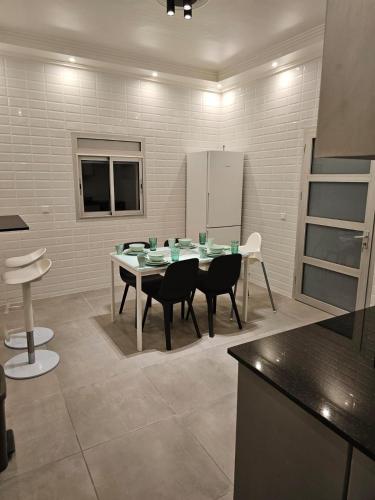a kitchen with a table with chairs and a refrigerator at Family Stay Ourzazate - Deluxe Appartments in Ouarzazate