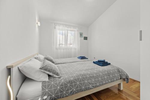 a white bedroom with a bed and a window at Apartman Lorena in Fažana