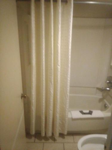 a bathroom with a shower curtain and a bath tub at King Bed Hotel Studio 140 in Livingston
