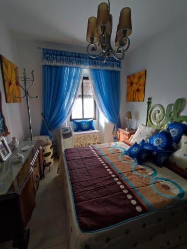 a bedroom with a large bed and blue curtains at Casa Due Amori in Montilla