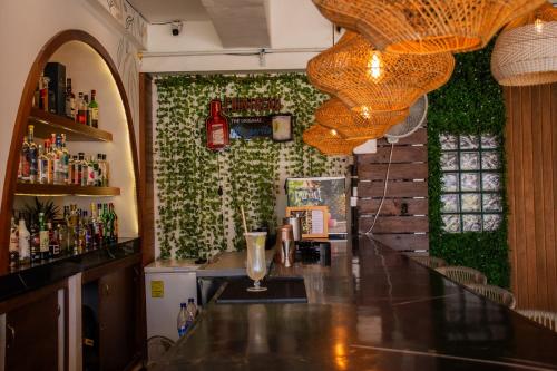 a bar in a restaurant with a green wall at Cache Hotel Boutique - Adults Only in Playa del Carmen