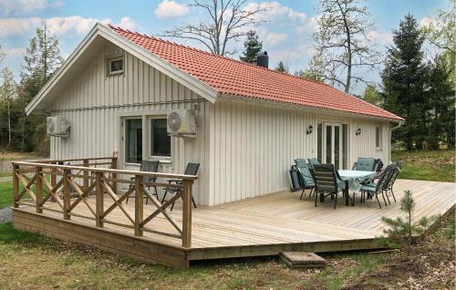 a house with a deck with a table and chairs at Nice Home In Norra Kedum With Wifi in Norra Kedum
