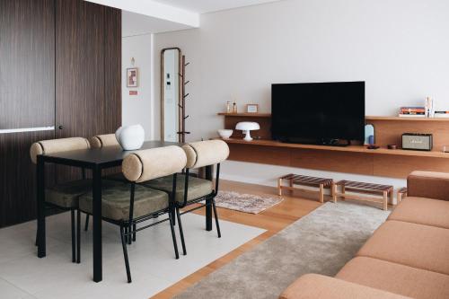 a living room with a table and chairs and a tv at Flair Living in Vila Nova de Gaia