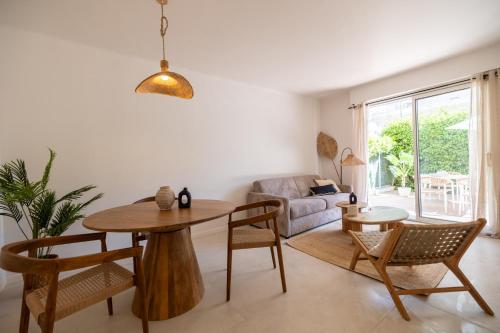 un salon avec une table, des chaises et un canapé dans l'établissement Place to beach - Bord de mer Croisette, à Cannes