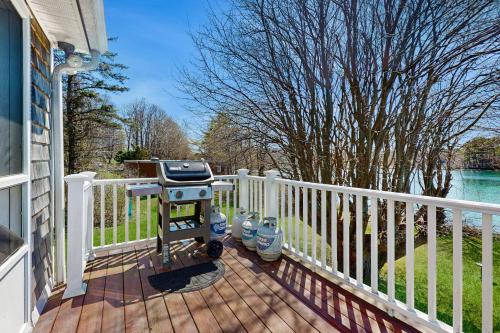 a grill on a wooden deck next to a fence at Wiggly Bridge Landing in York Harbor