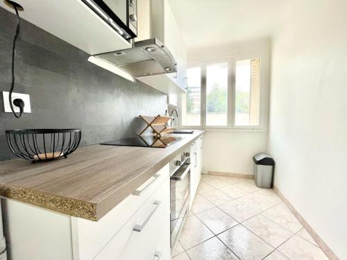 une cuisine avec des armoires blanches et un comptoir dans l'établissement Cocon à Gagny Accès rapide CDG, à Gagny