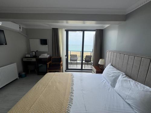 a bedroom with a bed and a view of the ocean at istanbul Airport Kumsal Otel in Arnavutköy