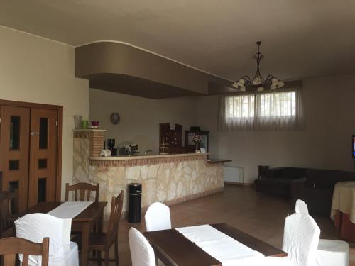 a living room with tables and chairs and a kitchen at La Dimora di Federico in Gravina in Puglia