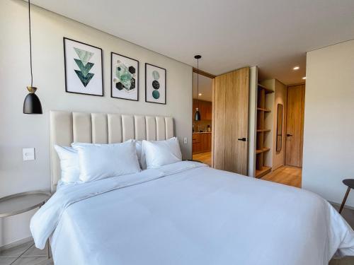 a bedroom with a large white bed with white pillows at Edificio QO 97 By Jalo in Bogotá