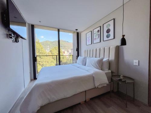 a bedroom with a large bed and a large window at Edificio QO 97 By Jalo in Bogotá