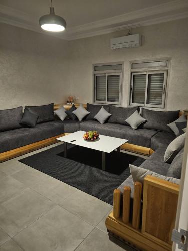 a living room with a couch and a table at Family Stay Ourzazate - Deluxe Appartments in Ouarzazate