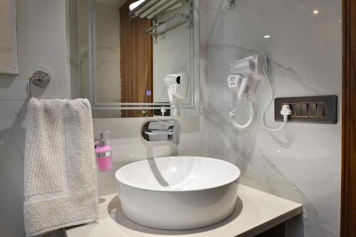 a bathroom with a white sink and a mirror at Hotel Grand Plaza in City Centre - Walking Distance From New Delhi Railway Station and Connaught Place in New Delhi