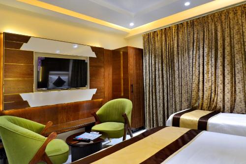 a hotel room with a bed and a tv at Hotel Grand Plaza in City Centre - Walking Distance From New Delhi Railway Station and Connaught Place in New Delhi