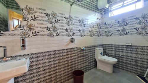 a bathroom with a toilet and a sink at Himalayan Horizon Deohari in Sainj
