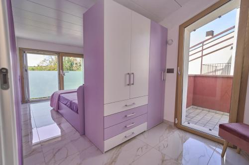 a purple dressing room with a large window at Rimini, 4 Camere con Giardino Privato e Parcheggio Gratuito, Relax a 10 Minuti dal Mare in Casalecchio