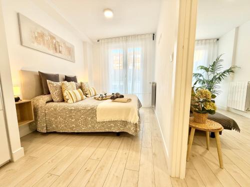 a bedroom with a bed and a table in it at Castro Holidays - Apto D Céntrico Terraza con Garaje Gratis in Castro-Urdiales