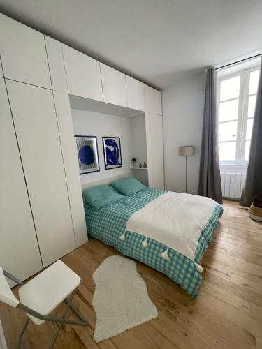 une chambre avec un lit et une chaise dans l'établissement Appartement rénové Bourse, à Bordeaux