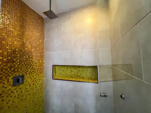 a bathroom with a shower with a tile wall at Cache Hotel Boutique - Adults Only in Playa del Carmen