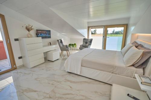 a white bedroom with a large bed and a desk at Rimini, 4 Camere con Giardino Privato e Parcheggio Gratuito, Relax a 10 Minuti dal Mare in Casalecchio