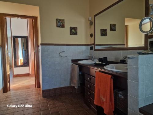 a bathroom with two sinks and a mirror at O Piñón in Santa Cristina de Cobres