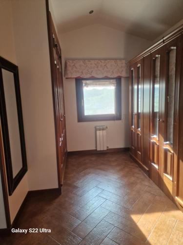 an empty room with a large window and wooden floors at O Piñón in Santa Cristina de Cobres