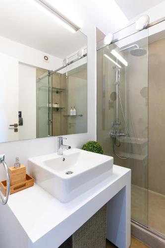 a white bathroom with a sink and a shower at Ma Maison No5, Private Heated Pool, Acropolis View in Athens
