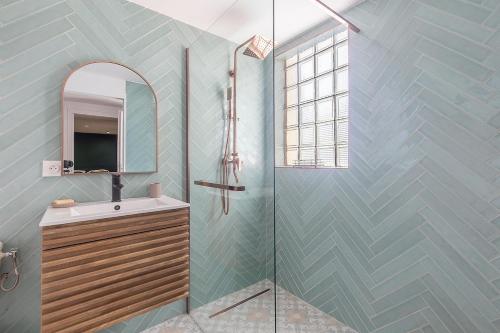 une salle de bain avec une douche avec un lavabo et un miroir dans l'établissement Villa Grazi, à Marseille
