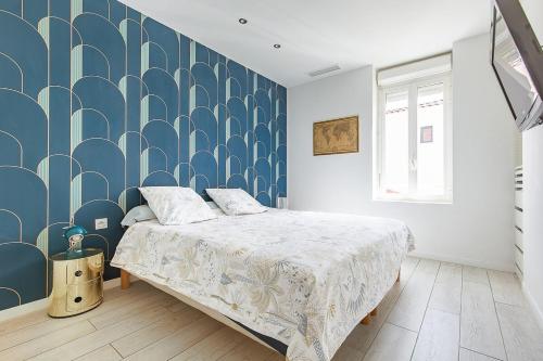 - une chambre avec un lit et un mur bleu et blanc dans l'établissement Villa Grazi, à Marseille