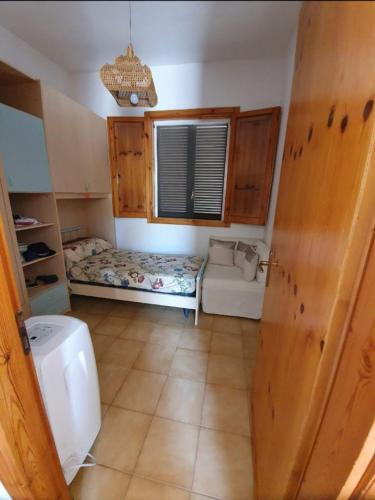a small room with a bed and a window at Casa vacanze Donna VALERIA in San Foca