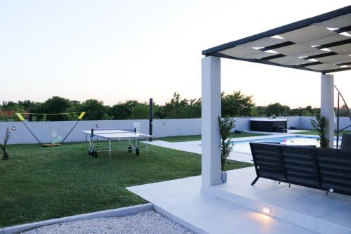 a pavilion with a ping pong table in a backyard at Villa Gemini in Zadar