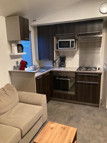 - une cuisine avec un canapé et une cuisinière four supérieur dans l'établissement Mobil Home Argelès, à Argelès-sur-Mer