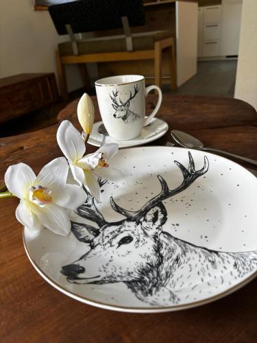 a plate with a picture of a deer on a table with a cup at Ferienwohnung Sonnenschein in Oberlienz