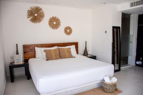 a bedroom with a white bed and two mirrors on the wall at Cache Hotel Boutique - Adults Only in Playa del Carmen