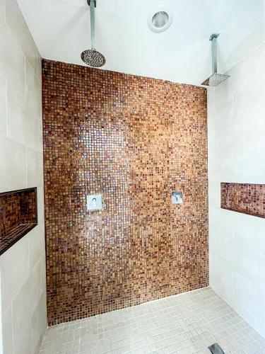 a bathroom with a brick wall with a shower at Cache Hotel Boutique - Adults Only in Playa del Carmen