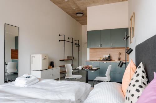 a room with a bed and a kitchen with a counter at Skyrise Apartments - Stilvoll wohnen, entspannt genießen in Bad Wörishofen