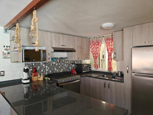 a kitchen with wooden cabinets and a counter top at Villa Ojo de Agua in Hacienda Ojo de Agua