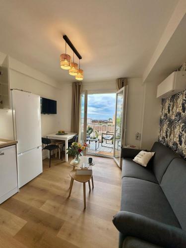 un salon avec un canapé et une table et une cuisine dans l'établissement Shiny Sea View Flat vue merTerrace in Cannes, à Cannes