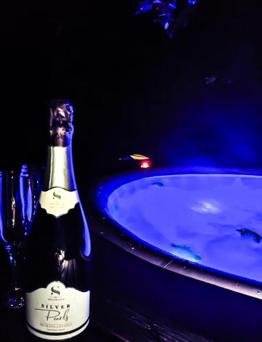 a bottle of wine sitting next to a bath tub at Silent Orchard in Naklo