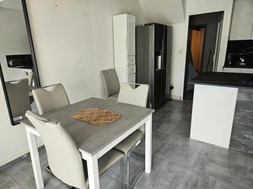 Il dispose d'une cuisine avec une table et des chaises blanches. dans l'établissement Résidence Héliovillage - VILLA T3 - 4 pers. CAP d'AGDE MAE-9611, au Cap d'Agde