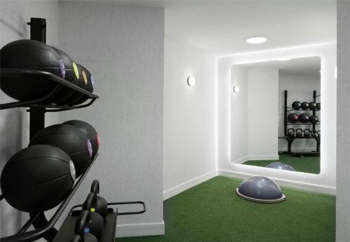 a room with a mirror and a gym with green carpet at Sonesta Los Angeles Airport LAX in Los Angeles