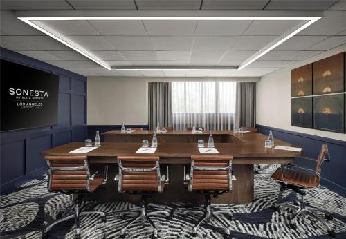 a conference room with a large wooden table and chairs at Sonesta Los Angeles Airport LAX in Los Angeles