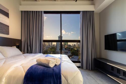 a hotel room with a bed with a large window at TOLIVE One Housi Recife by Carpediem in Recife