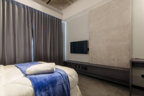 a bedroom with a bed and a flat screen tv at TOLIVE One Housi Recife by Carpediem in Recife