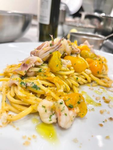a plate of pasta with shrimp and other foods at Rimini, 4 Camere con Giardino Privato e Parcheggio Gratuito, Relax a 10 Minuti dal Mare in Casalecchio