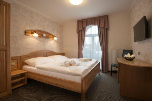 a hotel room with a bed and a window at Spa Hotel MILLENIUM Karlovy Vary in Karlovy Vary