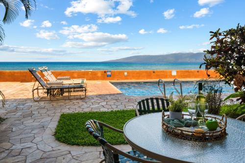un patio con tavolo e sedie e l'oceano di Nohonani 101 a Kahana
