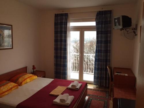 a bedroom with a bed with two towels and a window at Main Bus Terminal Rooms in Dubrovnik