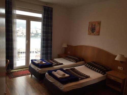 two twin beds in a room with a window at Main Bus Terminal Rooms in Dubrovnik