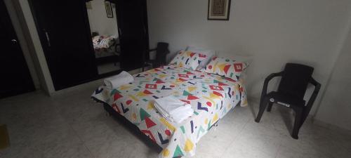 a bedroom with a bed and a chair and a mirror at Arena Dorada in Ríohacha