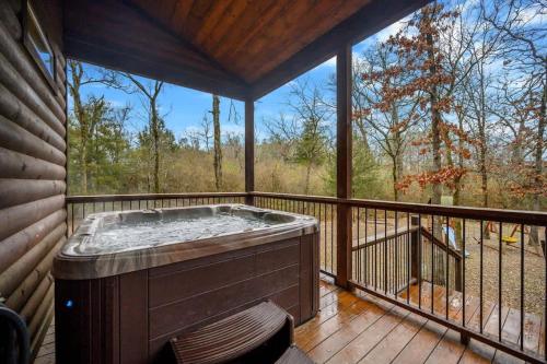 uma banheira de hidromassagem no deque de uma casa em Lazy Daze Lodge - Hot Tub Playset & Firepit em Broken Bow